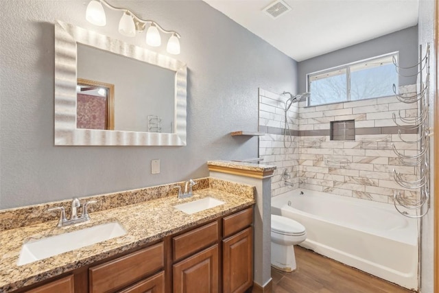 bathroom featuring visible vents, a sink, toilet, and wood finished floors