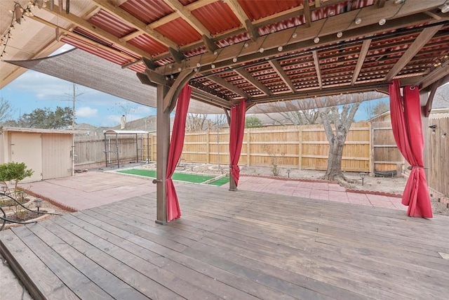 deck with a pergola, a fenced backyard, an outdoor structure, and a storage unit