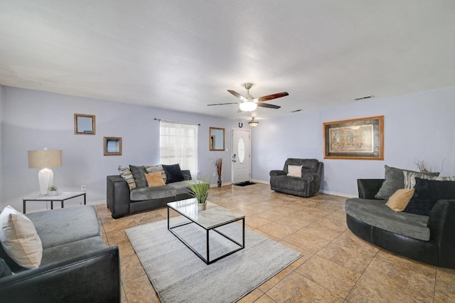 living area featuring baseboards, visible vents, and a ceiling fan