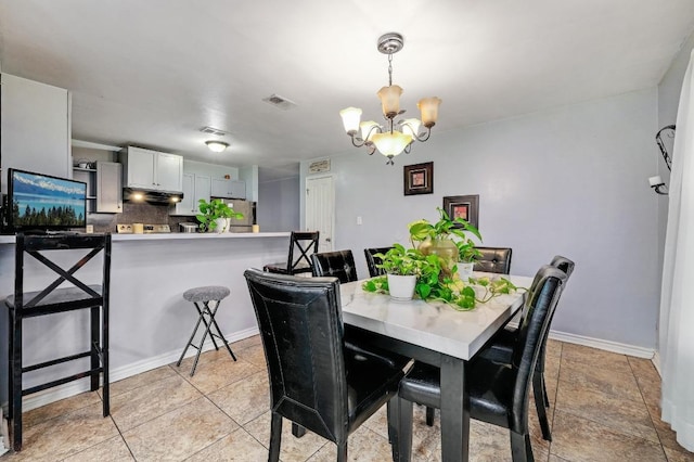 dining room featuring light tile patterned floors, baseboards, visible vents, and a chandelier