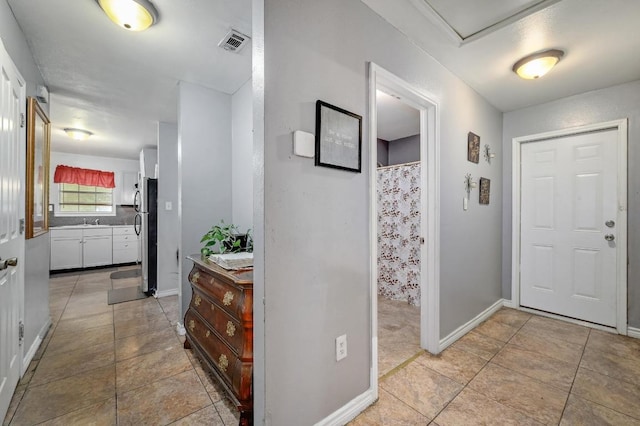 entrance foyer featuring baseboards, visible vents, and light tile patterned flooring