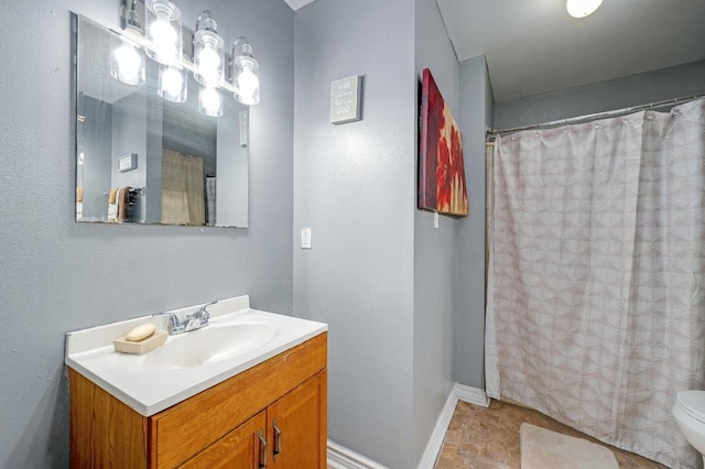 bathroom with toilet, baseboards, vanity, and a shower with curtain