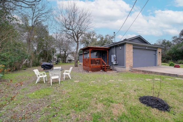 exterior space featuring a front yard, brick siding, driveway, and an attached garage