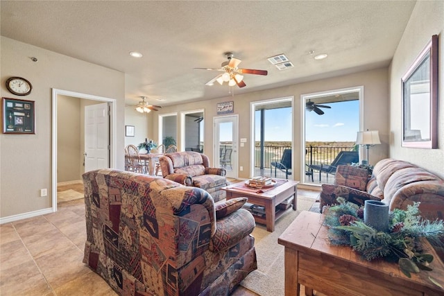 living area with a textured ceiling, light tile patterned floors, recessed lighting, and baseboards