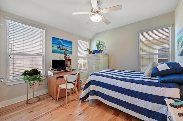 bedroom with a ceiling fan, lofted ceiling, light wood-style flooring, and baseboards