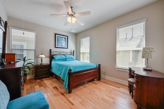 bedroom with ceiling fan, light wood-style flooring, and baseboards