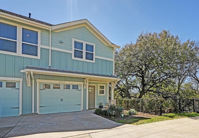 view of front facade featuring a garage, fence, board and batten siding, and concrete driveway