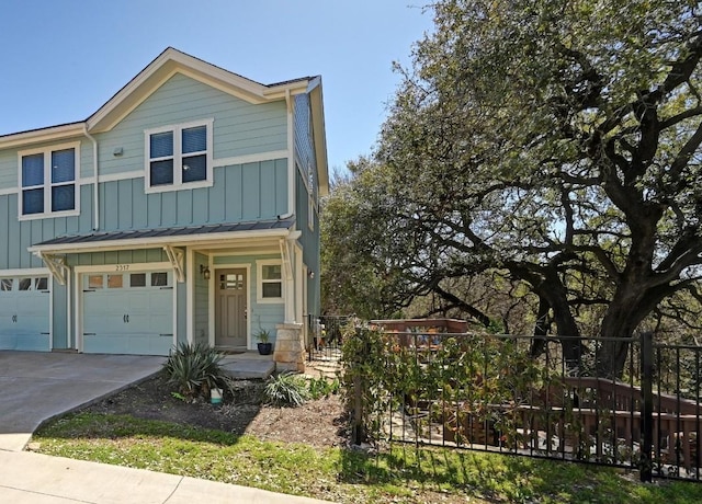 view of front of house with a garage, concrete driveway, board and batten siding, and fence