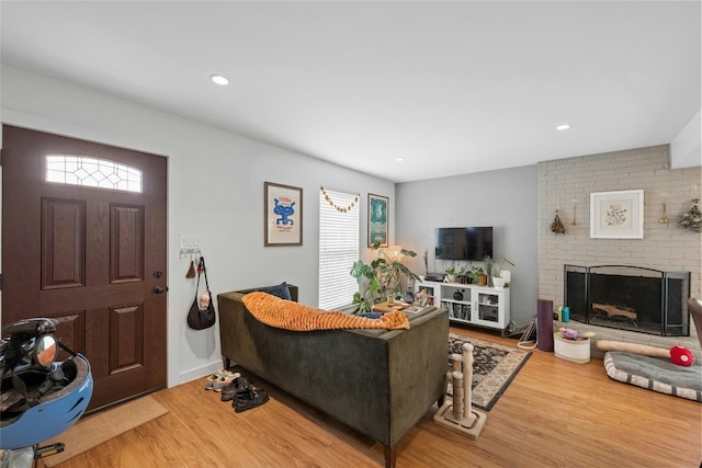 living area with recessed lighting, a fireplace, wood finished floors, and a healthy amount of sunlight