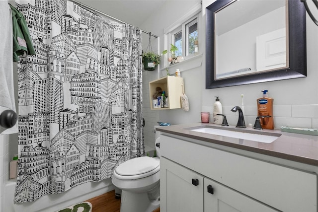 bathroom with toilet, shower / bathtub combination with curtain, wood finished floors, and vanity