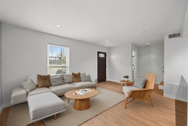 living room with light wood finished floors, visible vents, and recessed lighting