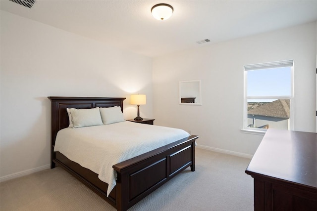 bedroom with visible vents, light carpet, and baseboards