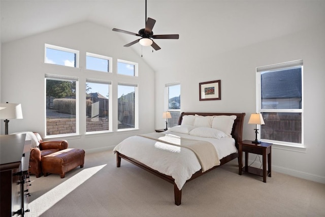 bedroom with baseboards, high vaulted ceiling, ceiling fan, and light colored carpet