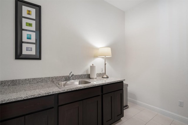 bathroom with tile patterned flooring, a sink, and baseboards