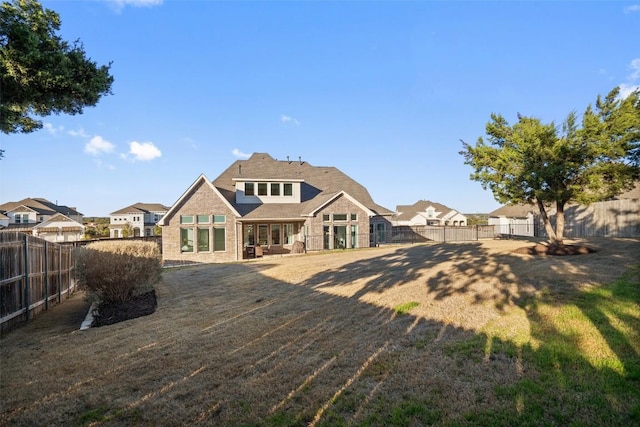 back of property featuring a fenced backyard and a lawn