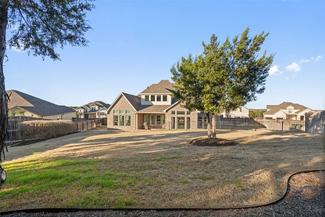 back of property featuring a yard, fence private yard, and a residential view