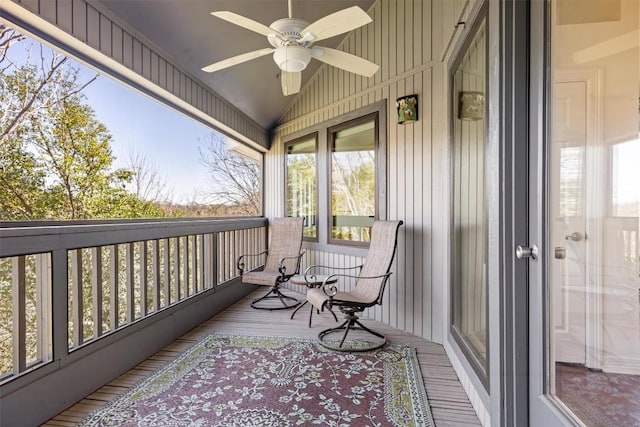 balcony featuring a sunroom and a ceiling fan