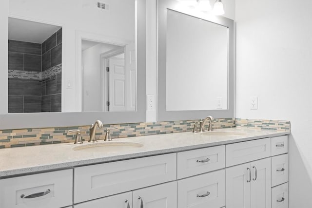 bathroom featuring backsplash, a sink, and visible vents