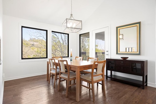 dining room featuring dark wood-type flooring, vaulted ceiling, baseboards, and an inviting chandelier