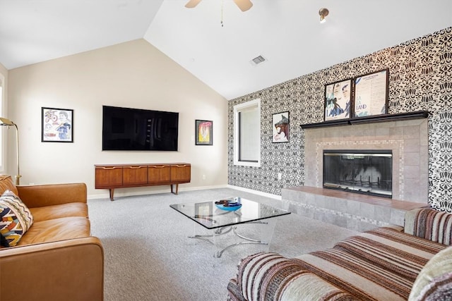 living area with lofted ceiling, carpet flooring, visible vents, baseboards, and a tiled fireplace