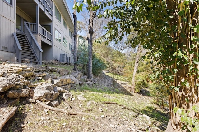 view of yard featuring stairs and central air condition unit