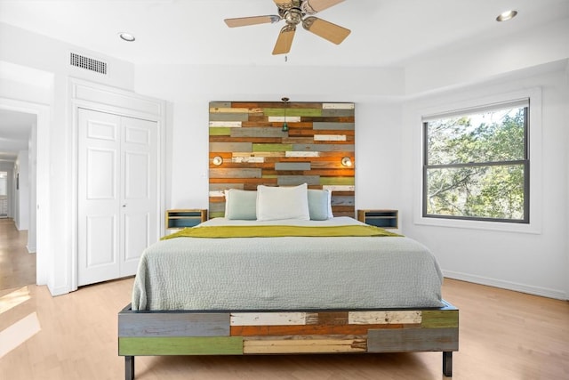 bedroom with baseboards, visible vents, light wood-type flooring, a closet, and recessed lighting