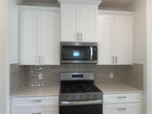 142 White Horses Dr, Kyle, TX 78640 - kitchen featuring stainless steel appliances, light countertops, white cabinets, and decorative backsplash