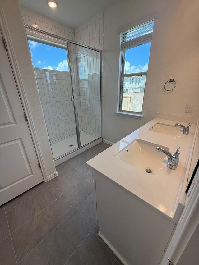 142 White Horses Dr, Kyle, TX 78640 - bathroom featuring a stall shower, double vanity, healthy amount of natural light, and tile patterned flooring