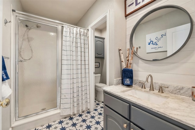 full bath with toilet, a shower stall, vanity, and tile patterned floors