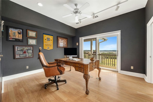 home office featuring baseboards, ceiling fan, visible vents, and light wood-style floors