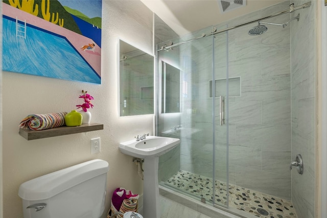 full bath with visible vents, a textured wall, a shower stall, and toilet