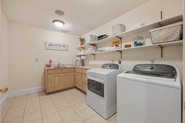 clothes washing area featuring light tile patterned floors, washing machine and dryer, a sink, visible vents, and cabinet space