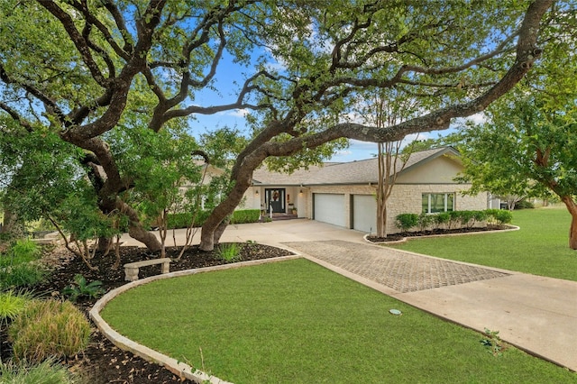 view of front of property with an attached garage, a front lawn, and decorative driveway