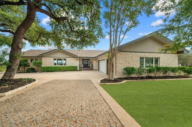 single story home with an attached garage, concrete driveway, stone siding, stucco siding, and a front lawn