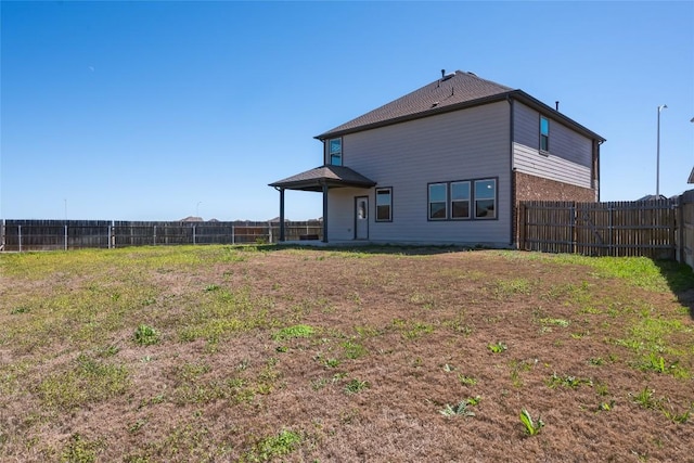 rear view of property featuring a fenced backyard