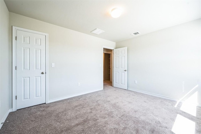 carpeted empty room featuring visible vents and baseboards