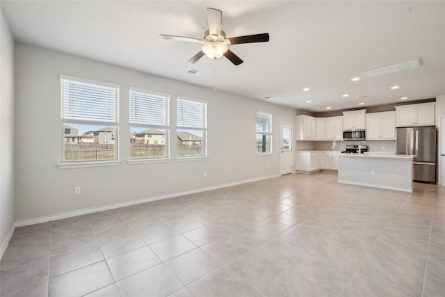 unfurnished living room featuring baseboards, visible vents, a ceiling fan, and recessed lighting