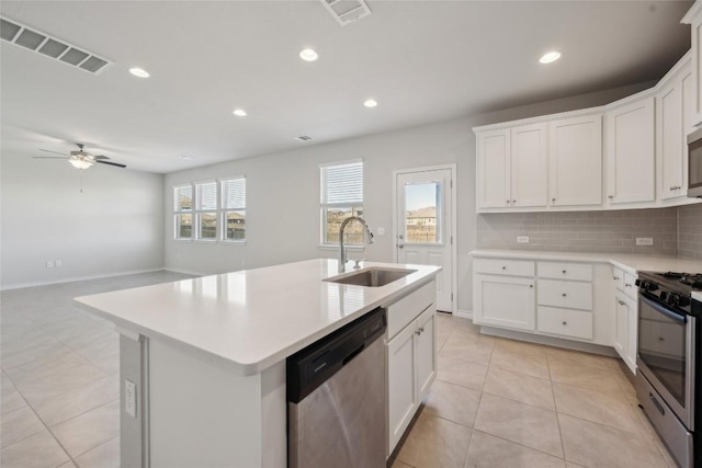 kitchen with stainless steel appliances, visible vents, a sink, and backsplash