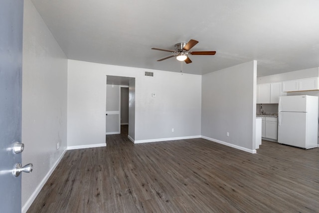 unfurnished living room featuring dark wood-style floors, visible vents, and baseboards