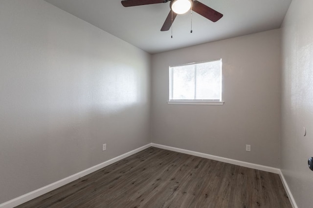 unfurnished room with dark wood-style flooring, a ceiling fan, and baseboards