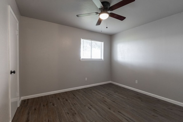 spare room featuring dark wood-style flooring, ceiling fan, and baseboards