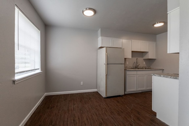 889 Lake St Unit 889A & B 890A & B, Somerville, TX 77879 - kitchen with freestanding refrigerator, a sink, dark wood-type flooring, white cabinets, and baseboards
