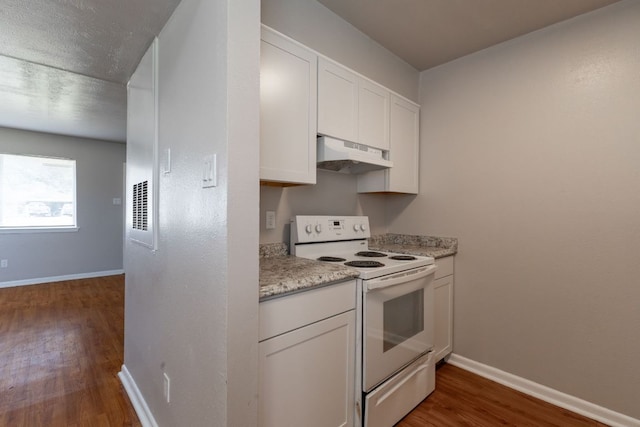 kitchen with under cabinet range hood, white electric range, dark wood-style flooring, baseboards, and white cabinets