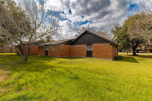 view of property exterior with brick siding and a lawn