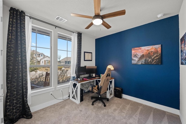 office area with baseboards, visible vents, ceiling fan, and carpet flooring