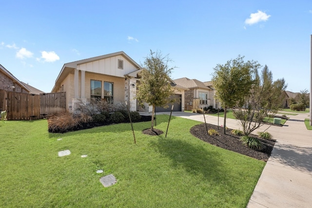 view of front of home featuring a front yard, concrete driveway, brick siding, and an attached garage