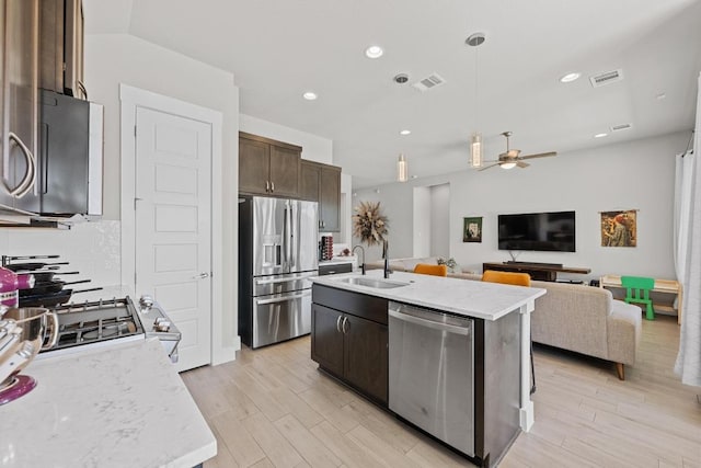 kitchen with visible vents, stainless steel appliances, a sink, and open floor plan