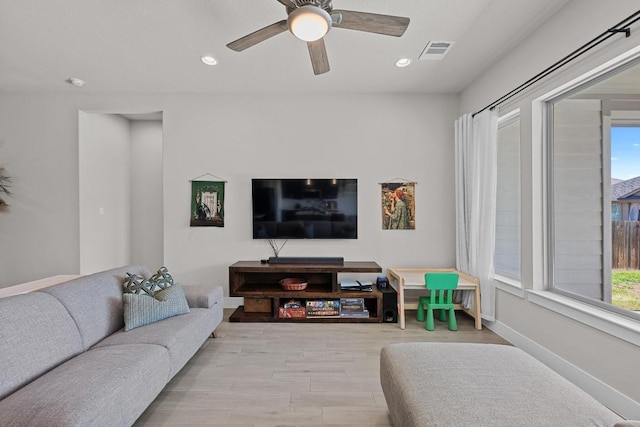 living area featuring baseboards, wood finished floors, visible vents, and recessed lighting