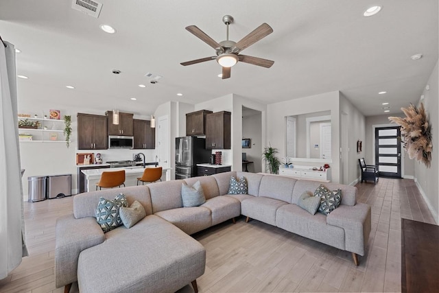 living area with ceiling fan, recessed lighting, visible vents, and light wood-style floors