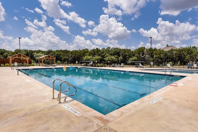 pool featuring fence, a gazebo, and a patio